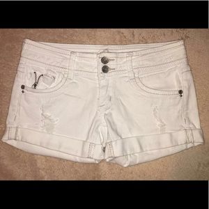 White jean shorts with rips.